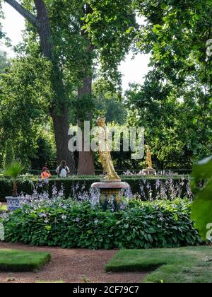 Statue d'or entourée de fleurs dans le parc inférieur de Peterhof, Russie Banque D'Images