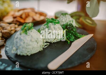 Plat agréable fait de fromage cottage garni d'algues vertes et placé sur un tableau d'ardoise Banque D'Images