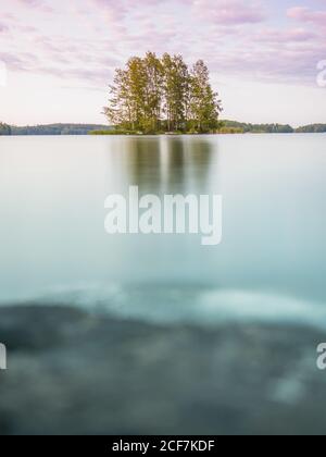 Paysage charmant et calme avec lac et île d'arbres à feuilles caduques En Finlande en été Banque D'Images