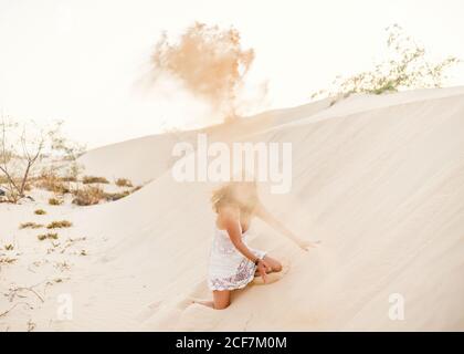 Femme ayant plaisir à jeter du sable dans le désert Banque D'Images