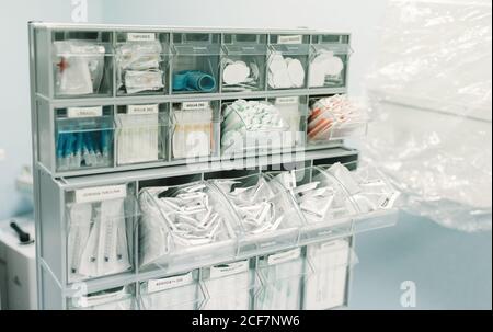Commode avec seringues stériles, bandages, ustensiles et différentes fournitures médicales en clinique Banque D'Images
