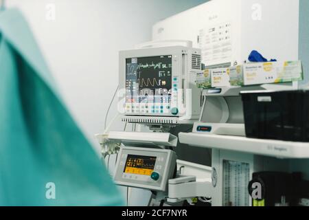 Équipement médical avec écrans indiquant les signes vitaux du patient hôpital et boîtes avec gants Banque D'Images