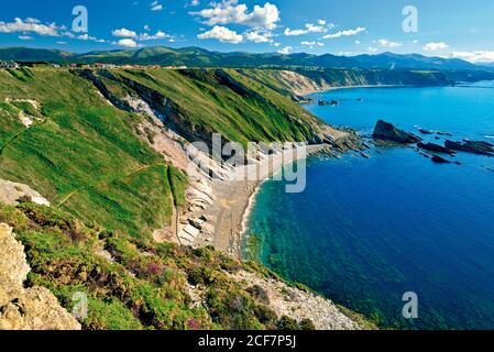 Superbe vue sur le bord de mer avec des falaises verdoyantes et des montagnes dans le arrière-plan Banque D'Images