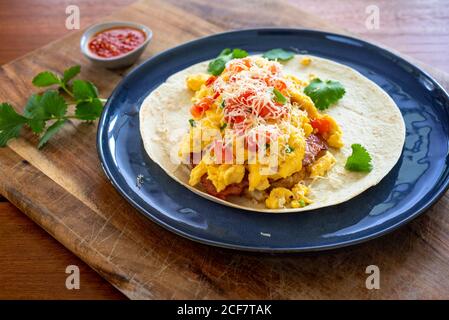 Petit déjeuner burrito avec œufs brouillés, tomates et fromage Banque D'Images