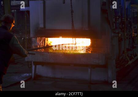 La trempe de l'acier à haute température dans les fours industriels à l'atelier d'une usine de forge. Processus de refroidissement, la chaleur traitemen. Forgeron et metallur Banque D'Images