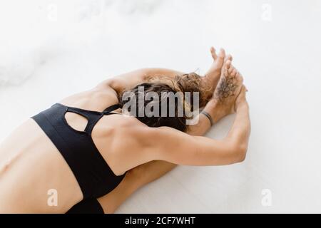 Femme sportive effectuant une pose de yoga dans la chambre Banque D'Images