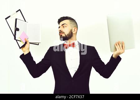 Barbu chef dans une tenue chère travaillant avec des dossiers, un organiseur, des autocollants et un ordinateur portable, isolé sur fond blanc, espace de copie. Concept de jour occupé Banque D'Images