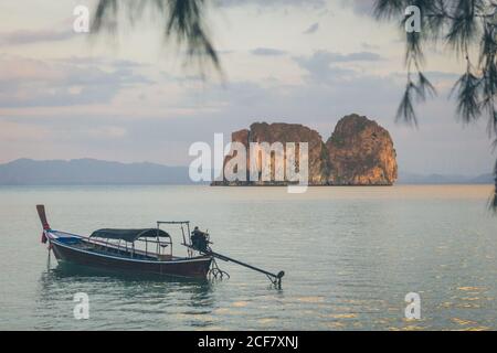 Petit bateau de pêche flottant sur une surface d'eau de mer tranquille Dans beau matin en Thaïlande Banque D'Images