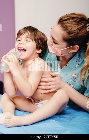 Un petit enfant utilise un inhalateur en clinique pendant le contrôle Banque D'Images