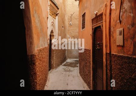 Passage étroit entre les vieilles maisons en pierre dans le style arabe traditionnel Avec des murs en chiche et des portes voûtées dans la ville de Marrakech à Maroc Banque D'Images