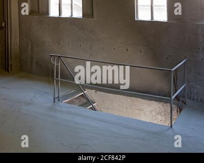 Intérieur du couloir avec rambardes en métal et escalier menant à sortie du bâtiment industriel par beau temps Banque D'Images