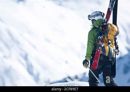 Les freeriders montent sur une colline abrupte lors d'une parfaite journée d'hiver Banque D'Images