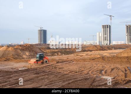 Vibration rouleau de route à cylindre unique nivelant le sol pour la fondation. Compacteur de sol pour la pose d'asphalte sur route sur le chantier de construction. Communication routière Banque D'Images
