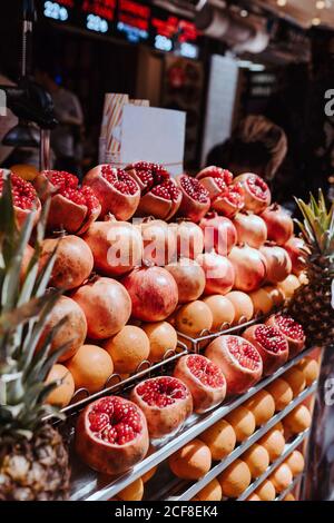 Grenades rouges mûres colorées et ananas doux exposés à Comptoir de fruits dans le marché à Istanbul l'été ensoleillé jour Banque D'Images
