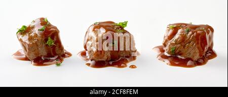 Cubes individuels de goulash de bœuf épicé avec de la sauce assaisonnée persil frais isolé sur blanc dans une bannière panoramique Banque D'Images