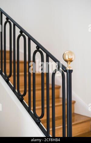 Escalier en bois massif avec balustrade noire dans la maison avec lumière intérieur Banque D'Images