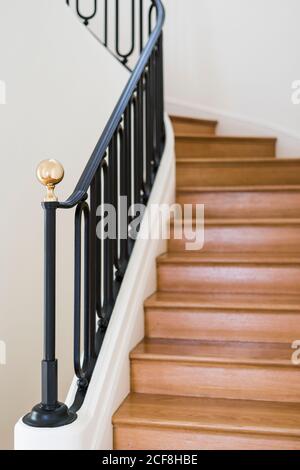 Escalier en bois massif avec balustrade noire dans la maison avec lumière intérieur Banque D'Images