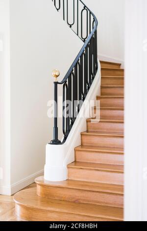 Escalier en bois massif avec balustrade noire dans la maison avec lumière intérieur Banque D'Images