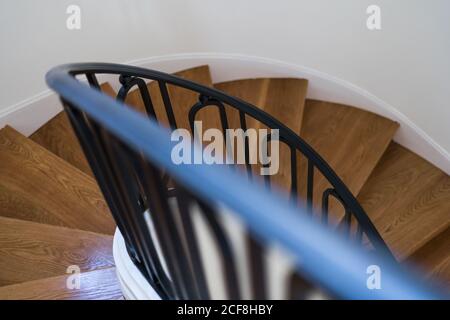 Escalier en bois massif avec balustrade noire dans la maison avec lumière intérieur Banque D'Images