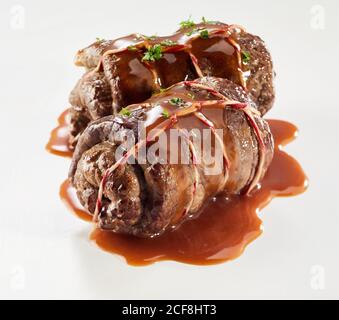 Double portion de roulades de bœuf en sauce garnie de frais persil haché isolé sur blanc Banque D'Images