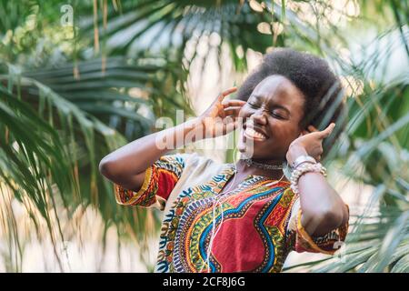 Femme noire souriante à l'écoute de musique Banque D'Images