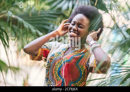 Femme noire souriante à l'écoute de musique Banque D'Images