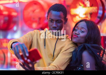 Couple noir prenant le selfie sur le champ de foire Banque D'Images
