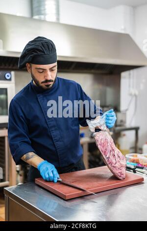 Cuire avec un grand morceau de viande crue dans la cuisine Banque D'Images