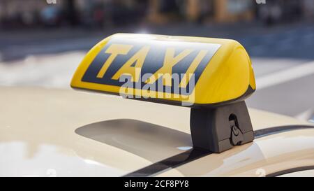 Panneau de taxi jaune sur une voiture pendant la journée à l'intérieur la ville Banque D'Images