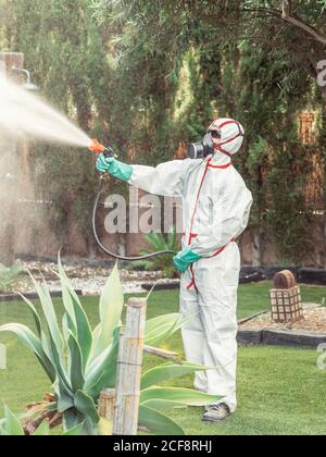 Fumeligator en substance blanche uniforme de pulvérisation sur le jardin Banque D'Images