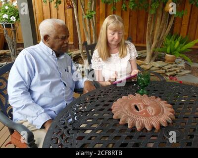 Santa Rosa, États-Unis. 31 août 2020. Astrid Granger et son mari Henry regardent des photos sur une tablette, tandis qu'un soleil de céramique, l'un des rares objets qu'ils pouvaient trouver dans les cendres de leur maison complètement détruite, est couché sur la table. Le couple avait perdu sa maison dans le quartier de Coffey Park en 2017 dans le feu de Tubbs à Santa Rosa. (À dpa 'la Californie se transforme en enfer de feu - pas de fin en vue') Credit: Barbara Munker/dpa/Alay Live News Banque D'Images