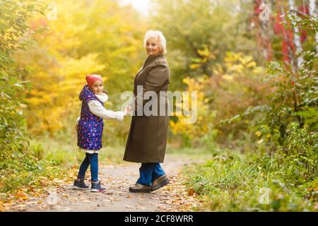 Grand-mère et sa petite-fille cueillir des baies dans la forêt Banque D'Images