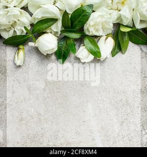 Mariage féminin, papier à lettres d'anniversaire, scène de maquette. Carte de vœux vierge avec bouquet de roses et de feuilles vertes. Fond gris en béton. Pose à plat, à Banque D'Images