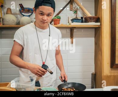 Ingrédients concentrés pour la friture de jeunes hommes pour la vaisselle japonaise appelée ramen Dans un restaurant asiatique Banque D'Images