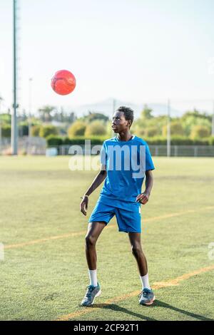 Ballon de football ethnique adolescent juglant Banque D'Images