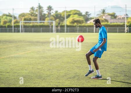 Ballon de football ethnique adolescent juglant Banque D'Images