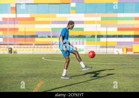 Ballon de football ethnique adolescent juglant Banque D'Images