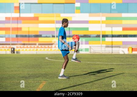 Ballon de football ethnique adolescent juglant Banque D'Images