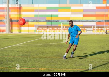 Ballon de football ethnique adolescent juglant Banque D'Images