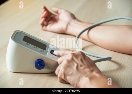Vue rapprochée de l'auto-mesure de la pression artérielle par pression du doigt sphygmomanomètre numérique Banque D'Images