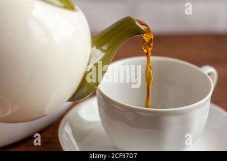 Le thé noir fraîchement préparé est versé dans une tasse Banque D'Images