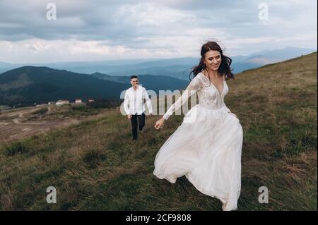 S'éloigner de son marié. Jour de mariage dans les montagnes. Banque D'Images