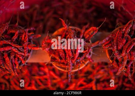 Vue de dessus des piments rouges chauds séchés disposés dans pots à vendre sur le marché Banque D'Images