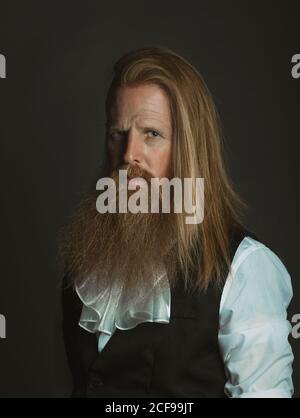 Adulte aux cheveux rouges, magnat médiéval confiant regardant l'appareil photo Banque D'Images