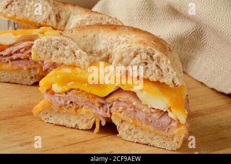 Un sandwich-déjeuner au jambon, aux œufs et au fromage sur un bagel multigrain Banque D'Images