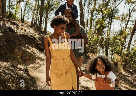 Belle famille marchant sur un sentier de montagne pendant leurs vacances. Famille de quatre randonnées dans un parc national. Banque D'Images