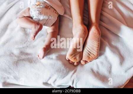 Vue de dessus de la petite petite bébé nouveau-né allongé sur la couche lit avec mère dans la maison Banque D'Images