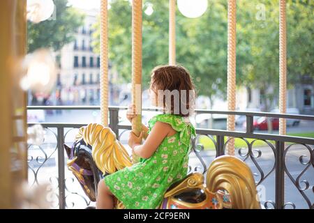 Charmante petite fille sur le joyeux émouvant coloré de faire le tour à salon en plein jour Banque D'Images