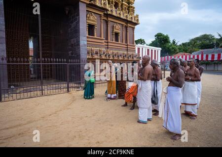 Jaffna, Sri Lanka - août 9 2019 : groupe de Tamouls en vêtements traditionnels debout près de l'entrée de la tour de gopuram tout en étant en pèlerinage lors du festival du Kovil de Nallur Kandaswamy Banque D'Images