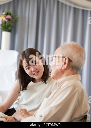 Un vieil homme parle heureusement avec sa petite-fille adulte Banque D'Images